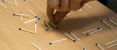 Hand playing with matches